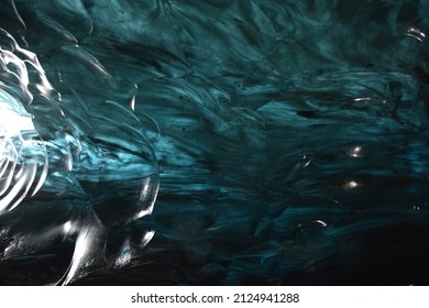 volcanic blue ice cave with lava ashes frozen in the ice