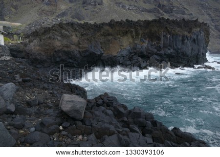 Volcanic coast landscape, waves braking against lava rocks in La Palma, Canary Islands, Spain.