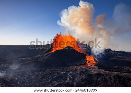 A volcanic eruption creating a massive cloud of smoke in the sky, spewing lava and ash into the atmosphere. This event can cause significant changes to the landscape. Iceland
