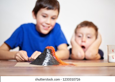 volcanic eruption. school science project. Two boys watching a chemistry experiment. children surprised. Chemical reaction of baking soda and vinegar - Powered by Shutterstock