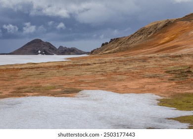 Volcanic landscape of Leirhnjukur, Myvatn Geothermal Area in Iceland, with hills and lava fields covered with moss, grass and snow. - Powered by Shutterstock