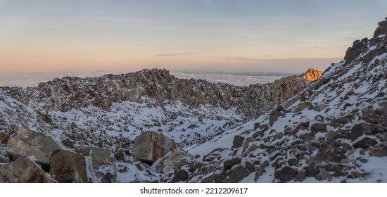 Volcanic Mountain Covered In Snow During Sunset