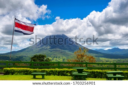 Volcano Arenal with national flag of Costa Rica. La Fortuna. Central America. Beautiful nature.