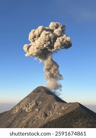 A volcano rises through a veil of clouds, with smoke billowing from its crater. The dramatic scene captures the raw power of nature, evoking a sense of awe and mystery in the midst of the volcanic