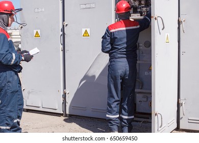 VOLGOGRAD, RUSSIA - April 27, 2017: The Duty Electrician Of Power Transformer Substation In Overalls And A Protective Helmet Makes Expeditious Switchings 