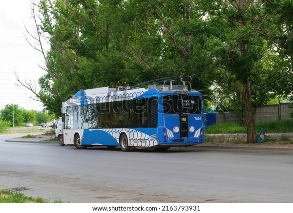 Volgograd, Traktorozavodsky\
district, Russia, June 1, 2021. Electric bus, electric bus on a\
shady street of the city, terminus, a new kind of urban electric\
transport.