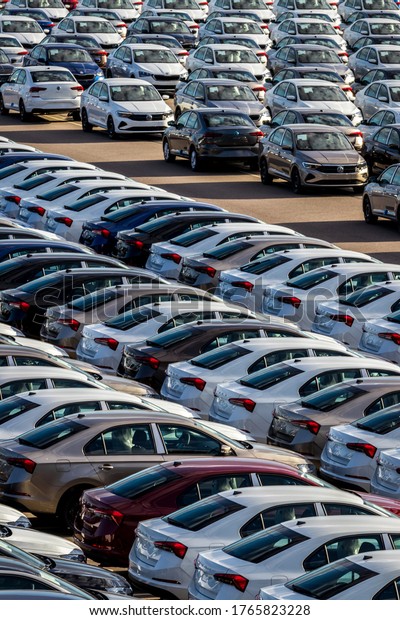 Volkswagen Group Rus, Russia,\
Kaluga  - MAY 25, 2020: Rows of a new cars parked in a distribution\
center on a sunny day in the spring. Parking in the open\
air.