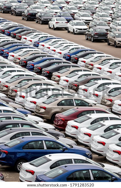 Volkswagen Group\
Rus, Russia, Kaluga  - MAY 24, 2020: Rows of a new cars parked in a\
distribution center on a cloudy day in the spring, a car factory.\
Parking in the open\
air.