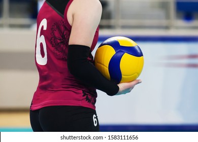 The volleyball ball is on the volleyball player's hand