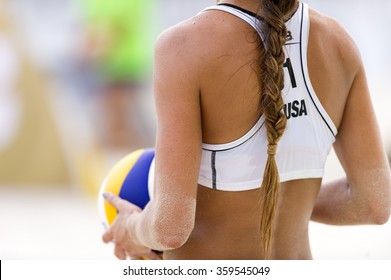 Volleyball beach player is a female athlete volley ball player getting ready to serve the ball.