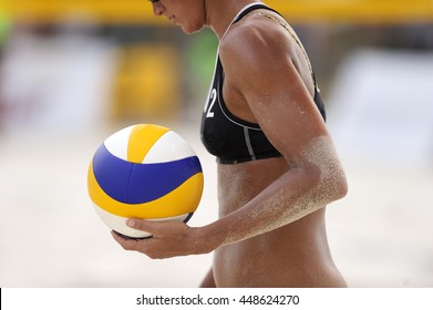 Volleyball beach player is a female athlete volleyball player getting ready to serve the ball on the beach.