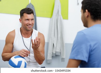 volleyball coach talking to players in court - Powered by Shutterstock