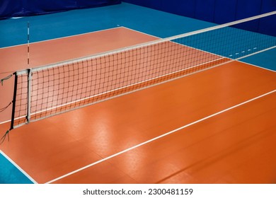 Volleyball court with net in old school gym, top view, copy space. Backdrop sports image of volleyball courts in sport hall. Concept of team game, active match, healthy lifestyle and team success