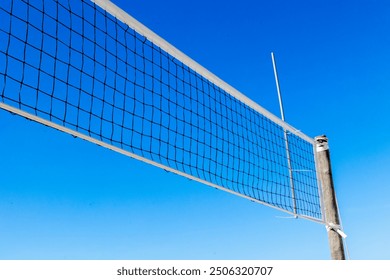 Volleyball court on the sand beach with the volleyball net. Sunny sky background in the summertime - Powered by Shutterstock