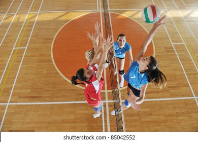 Volleyball Game Sport With Group Of Young Beautiful  Girls Indoor In Sport Arena