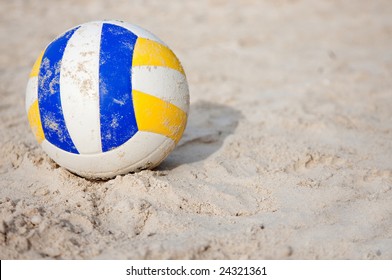 Volleyball lying still on the sand at a beach