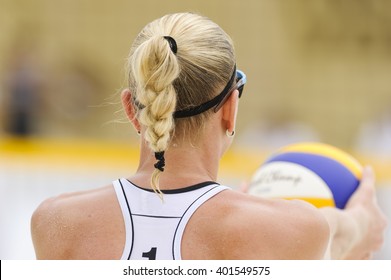 Volleyball player is a female athlete getting ready to serve the ball.