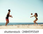 Volleyball players enjoying a sunny day at the beach, young man and woman playing beach volleyball under clear blue sunny sky. Concept of sport, summer, nature, active lifestyle, youth