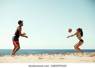 Volleyball players enjoying a sunny day at the beach, young man and woman playing beach volleyball under clear blue sunny sky. Concept of sport, summer, nature, active lifestyle, youth - Powered by Shutterstock