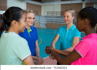 Volleyball players with their hands stacked in court - Powered by Shutterstock