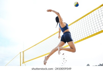 Volleyball, sports and woman jump at beach to hit ball in competition, game or match. Training, exercise and female athlete jumping for spike in tournament for workout, fitness and health at seashore - Powered by Shutterstock