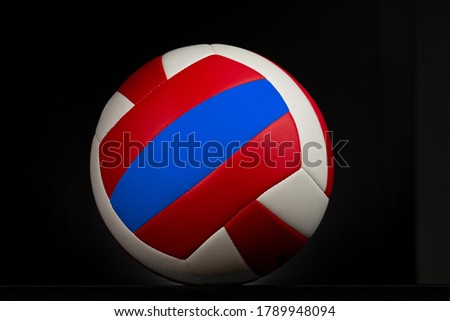 Volleyball in a studio shot. The ball is over a black background that is lightly illuminated.