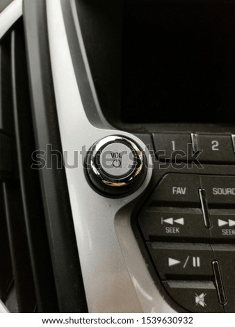 Volume and power on button with chrome on car stereo entertainment system beside vent.