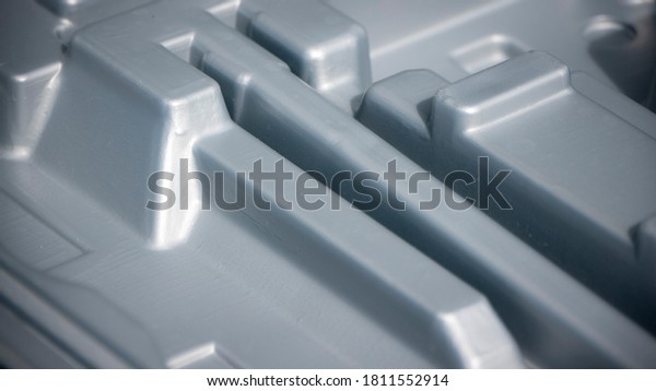 Volumes\
and hollows in grey plastic packaging\
interior