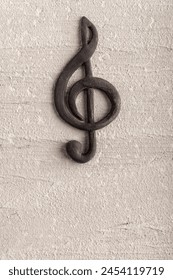 Volumetric black treble clef on rough surface. Music concept. Music symbol. Key of G. Vertical frame.