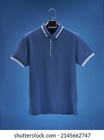 Voluminous Polo Shirt Hanging On Hanger, Dark Blue Background Colours, White, Beige, Blue