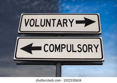 Voluntary Versus Compulsory Road Sign With Two Arrows On Blue And Grey Sky Background. White Two Street Sign With Arrows On Metal Pole. Two Way Road Sign With Text.