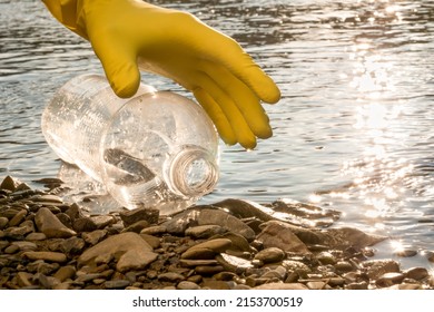 Volunteer cleaning river trash pick up litter picking shore. Collect garbage river. Picking up garbage water plastic nature. Cleaning beach waste plastic bottle PET. Cleaning trash beach garbage shore