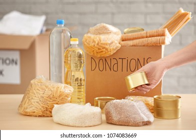 Volunteer Collecting Food Into Donation Box Indoors