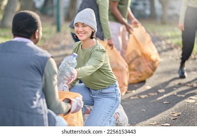 Volunteer, community service and people cleaning plastic in park with garbage bag. Happy woman and man team help with trash for eco friendly lifestyle and recycling in nature for a clean enviroment
