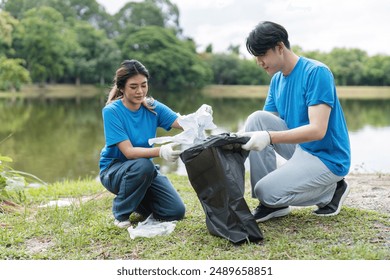 Volunteer Couple Collecting Trash in Park by Lake, Environmental Cleanup, Community Service, Eco-Friendly Activity, Teamwork, Nature Conservation, Outdoor Volunteering - Powered by Shutterstock