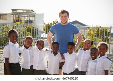 Volunteer And Elementary School Kids In Playground, Portrait