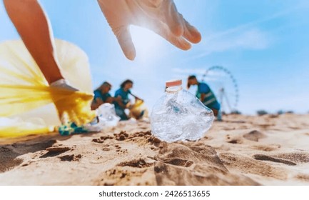 A volunteer group cleaning up the beach,someone picking bottle into plastic bag  for cleaning the beach in morning time, Volunteer concept. - Powered by Shutterstock