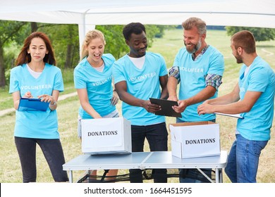 Volunteer Group Volunteer In Fundraiser With Donation Box