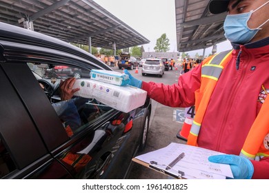 A Volunteer Hands Baby Essentials To A Passenger During A ''Let's Feed L.A. County'' Drive Thru Food Distribution By The Los Angeles Regional Food Bank, April 23, 2021, In Rosemead, California.