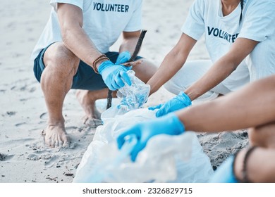 Volunteer, hands of people cleaning beach for world earth day with nature care and kindness for natural environment. Help, recycling and ngo team picking up plastic waste and pollution on ocean sand.