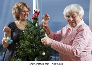 Volunteer Helping Senior Decorate Her Christmas Tree