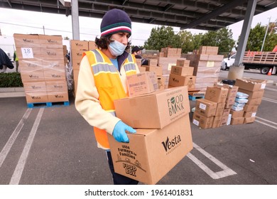 A Volunteer Loads Food Into The Trunk Of Vehicles During A ''Let's Feed L.A. County'' Drive Thru Food Distribution By The Los Angeles Regional Food Bank, April 23, 2021, In Rosemead, California.