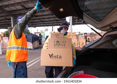 A Volunteer Loads Food Into The Trunk Of Vehicles During A ''Let's Feed L.A. County'' Drive Thru Food Distribution By The Los Angeles Regional Food Bank, April 23, 2021, In Rosemead, California.