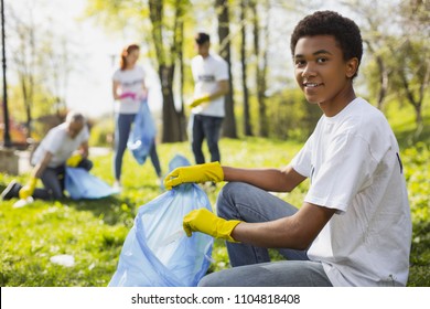 Volunteer Opportunities. Attractive Male Volunteer Using Garbage Bag While Staring At Camera