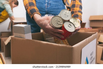 The volunteer packing the bag with groceries and necessary things for people in need - Powered by Shutterstock