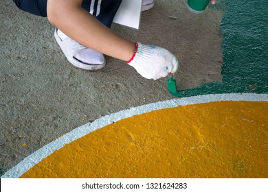 Volunteer Painting Stadium Floor By Hand.