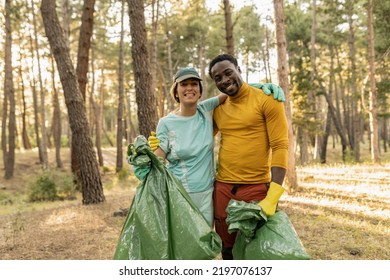 volunteer people collecting garbage in forest smiling, multiracial couple environmentalists. - Powered by Shutterstock