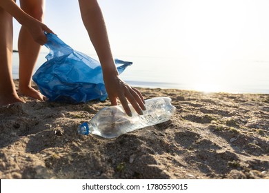 Volunteer Picking Up Plastic Bottle On Polluted Beach During Ocean Coastal Cleanup Outside. Cropped, Free Space For Text