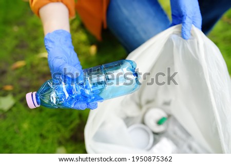 Volunteer picking up the plastic garbage and putting it in biodegradable trash-bag on outdoors. Ecology, recycling and protection of nature concept. Environmental protection.