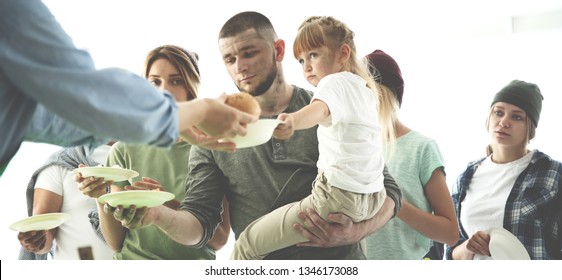 Volunteer Serving Food For Poor People Indoors